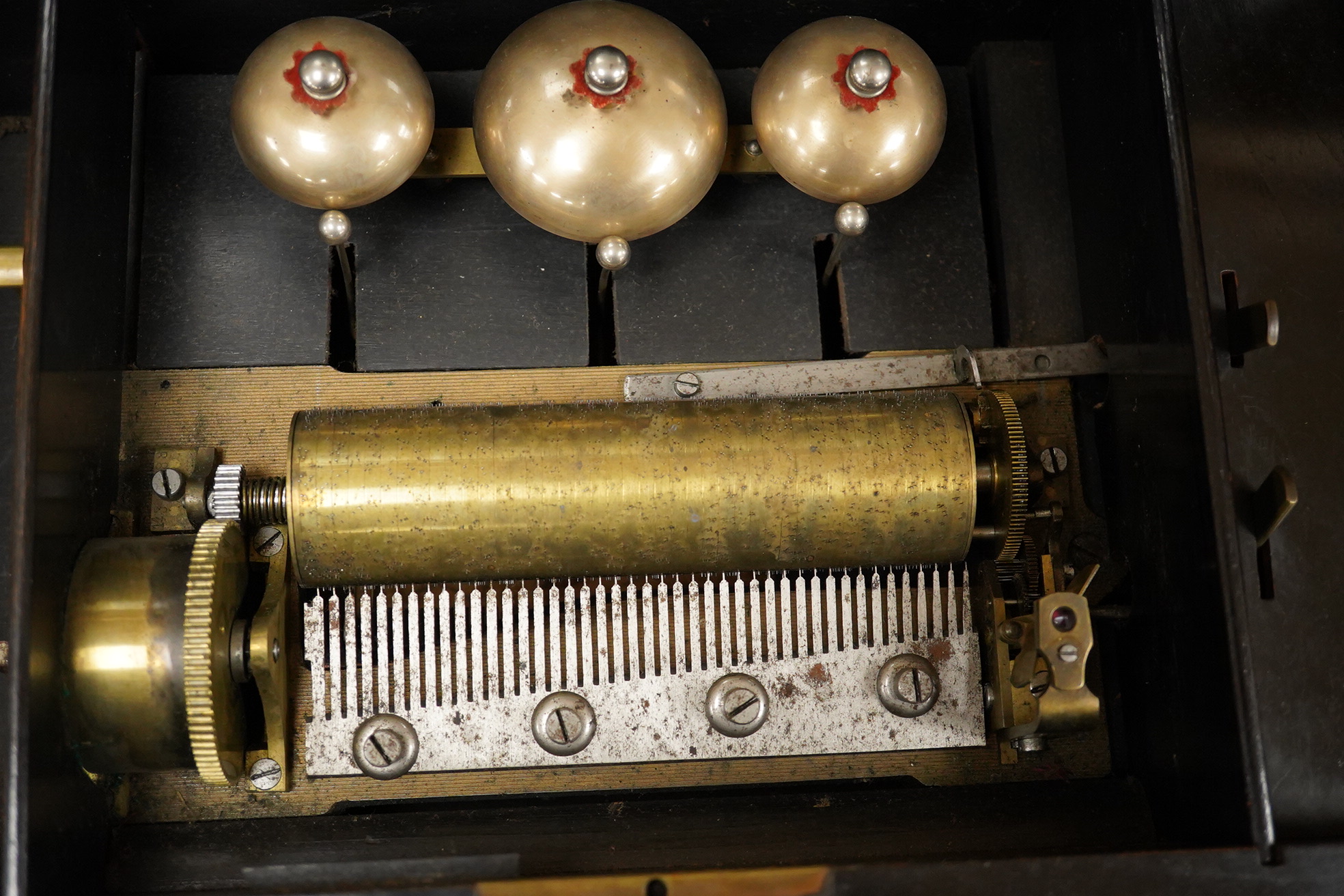 A mid-19th century inlaid and ebonised rosewood Swiss cylinder music box playing eight airs on a cylinder and three bells, card label to the inside of the lid listing the airs, complete with all teeth to the comb, cylind